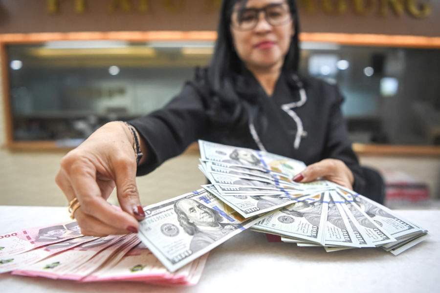 Karyawan menghitung lembaran uang pecahan rupiah dan dolar Amerika Serikat di salah satu gerai penukaran mata uang asing di Jakarta.