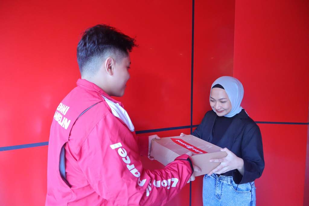 Tampak petugas kurir Lion Parcel sedang memegang paket kiriman berukuran kecil dengan layanan MINIPACK di area operasional Jakarta.
