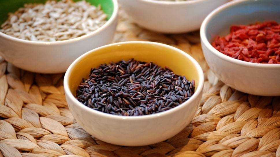 Semangkuk lulur tradisional badabida berbahan dasar ketan hitam dengan taburan rempah alami khas Sulawesi Tengah di atas meja kayu.