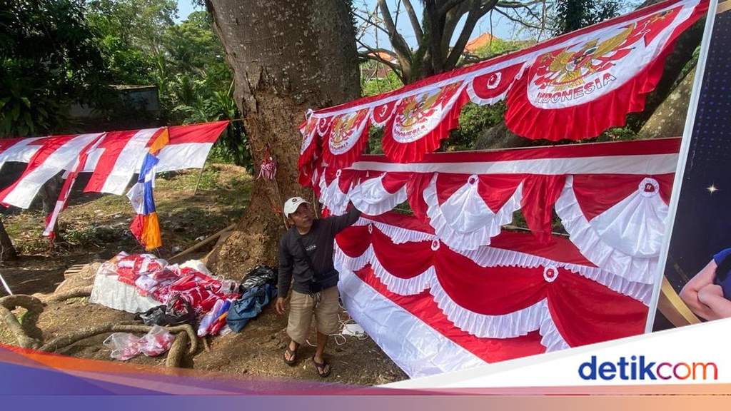 Seorang pedagang musiman menjajakan berbagai ukuran bendera merah putih di pinggir jalan raya Kabupaten Karangasem Bali menjelang perayaan kemerdekaan.