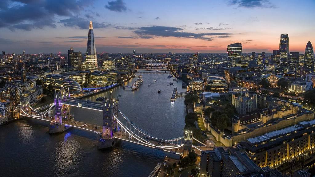 Pemandangan udara kota London yang menampilkan Sungai Thames, jembatan ikonik, serta deretan gedung pencakar langit di kawasan pusat keuangan.