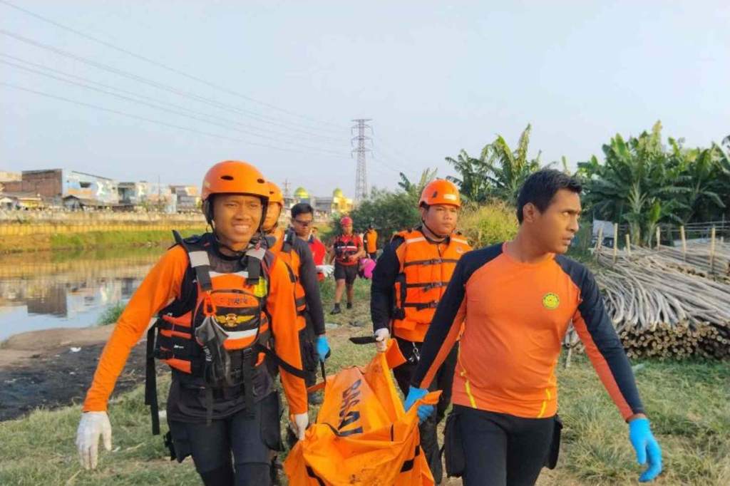Petugas kepolisian dan tim penyelamat berada di sekitar aliran Kali Banjir Kanal Barat, Grogol Petamburan, Jakarta Barat, lokasi penemuan jasad pemuda.