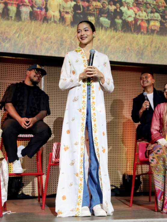 Putri Marino tampil modis mengenakan kebaya putih bermotif bunga merah yang dipadukan dengan celana jeans belel dan sneakers putih saat merayakan Hari Kebaya Nasional.