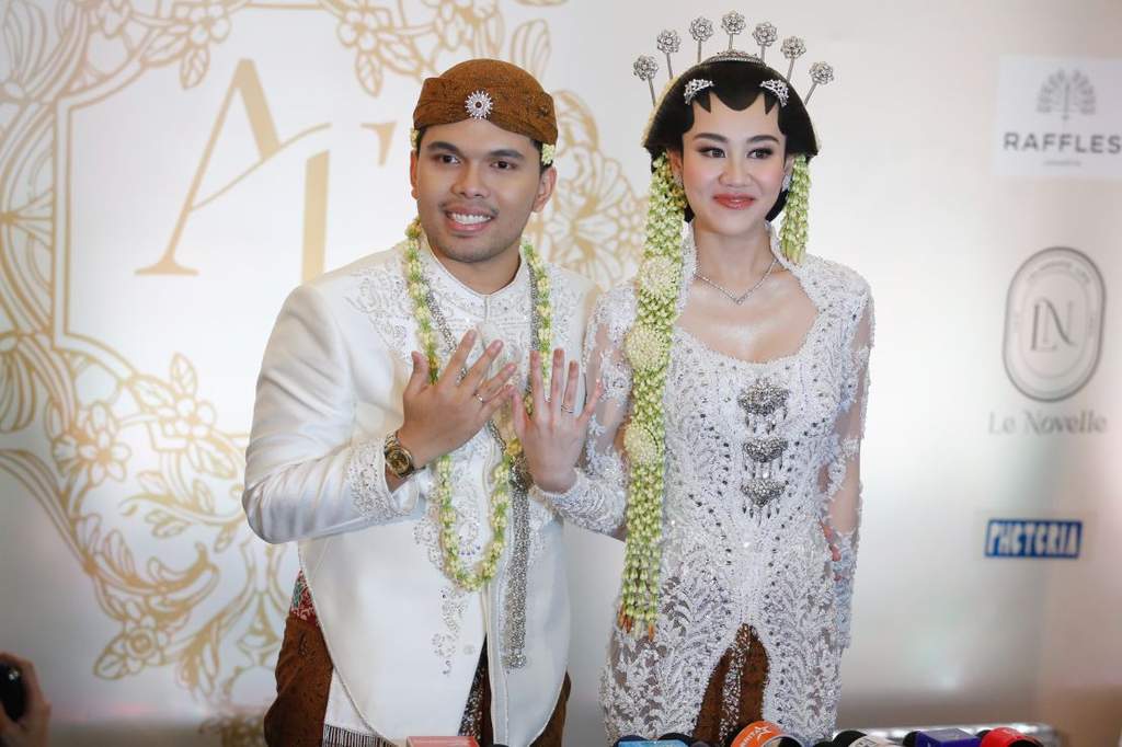 Thariq Halilintar dan Aaliyah Massaid menunjukkan buku nikah dan senyum bahagia usai jalani prosesi akad nikah di Hotel Raffles Jakarta mengenakan busana adat Jawa bernuansa krem.